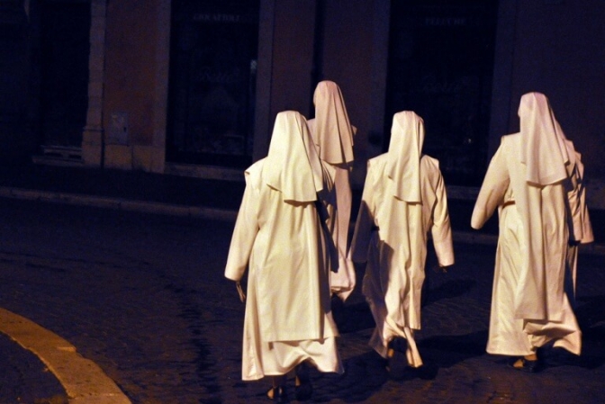 Nonnerne næsten svæver hen over gaden i et uvirkeligt lys.